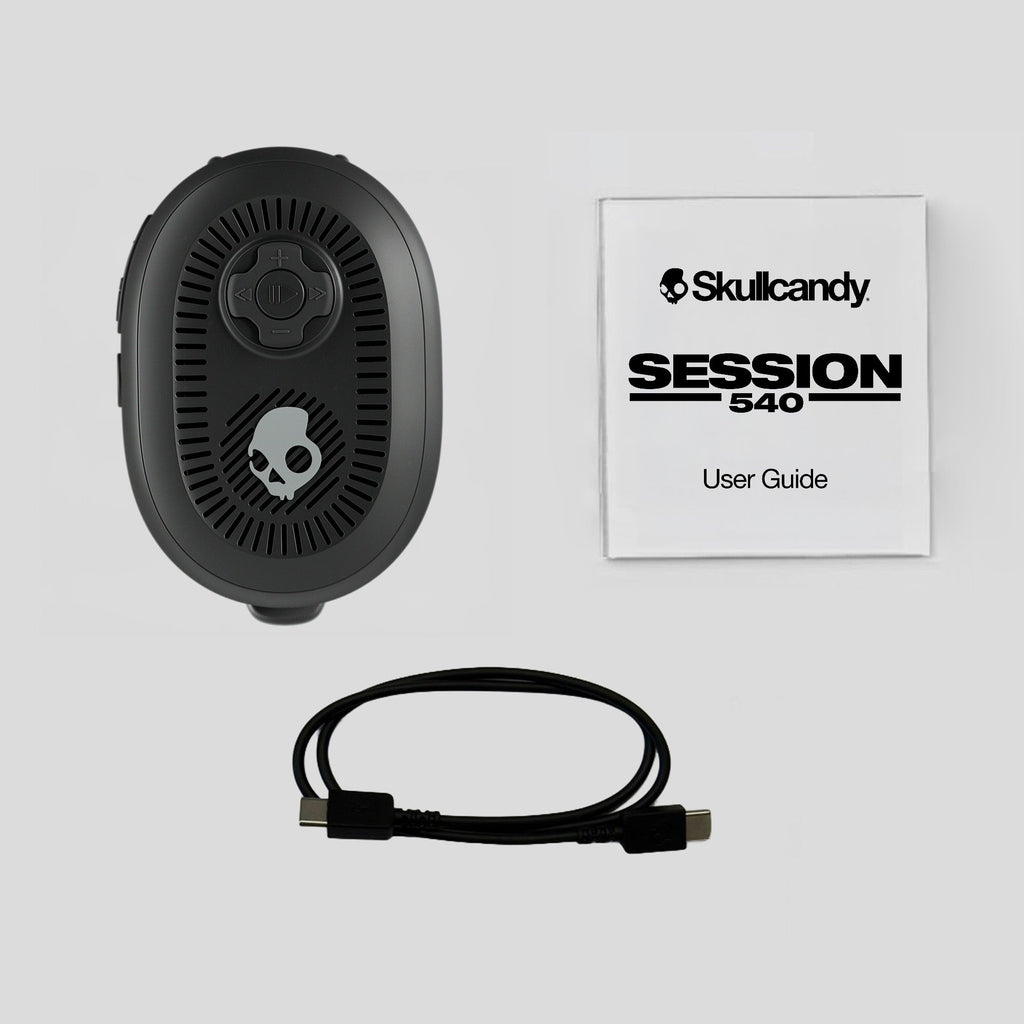 Black electronic device with cable and Skullcandy user guide on a light gray background | True Black